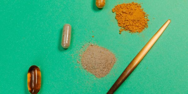Cápsulas e pó de suplemento sobre uma superfície, sem identificação de marca