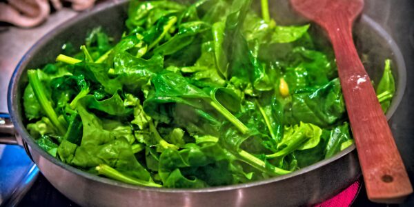 Folhas verdes refogadas numa frigideira, preparo semelhante ao usado com a ora-pro-nóbis