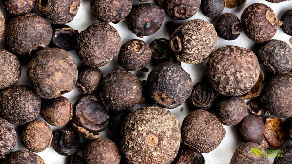 Grãos inteiros de pimenta-da-jamaica, exibindo sua textura rugosa e cor marrom-avermelhada característica. Esta imagem destaca a forma como a especiaria é mais comumente encontrada e vendida, preservando seu aroma e sabor intensos até o momento do uso.